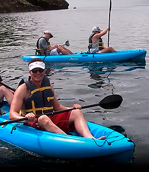 Passengers enjoying kayaking in the galapagos islands on a luxury cruise ship